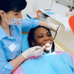 Dentista a realizar um check-up dentário para mostrar de quanto em quanto tempo ir ao dentista, prevenindo cáries e problemas gengivais.